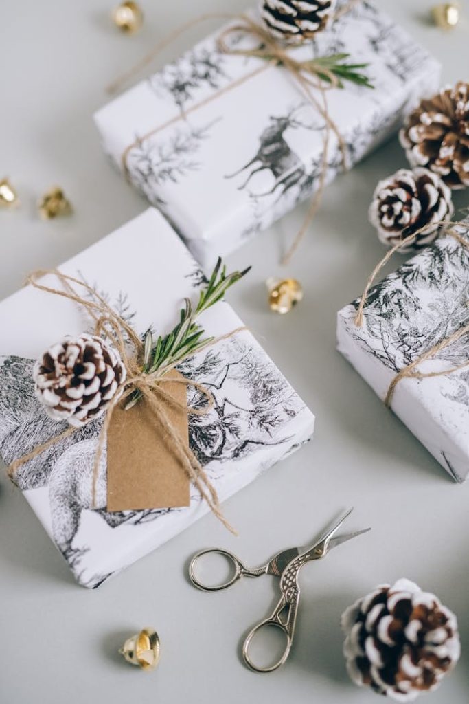 High-angle view of rustic Christmas gifts wrapped with twine and pine cones, featuring a cozy winter aesthetic.